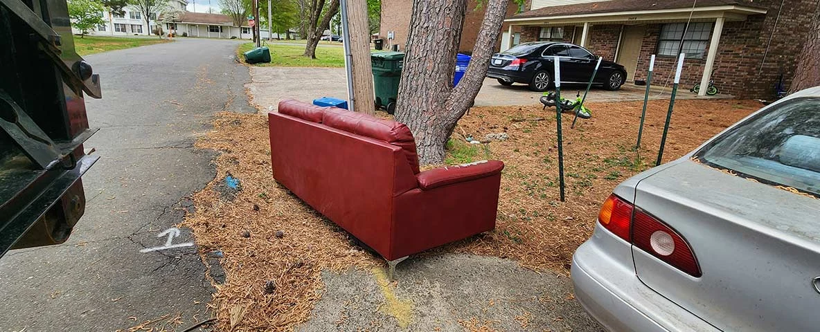 Red sofa on curb waiting to be removed